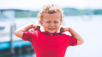 Little kid in red shirt flexing